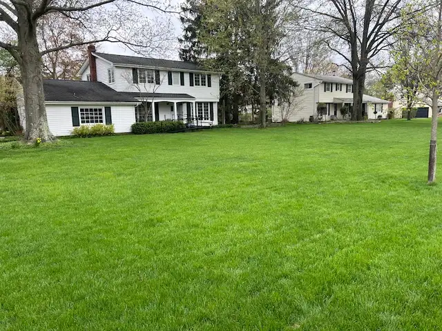 Weed-free residential lawn in front of a colonial home treated by Field of Dreams Lawn Care