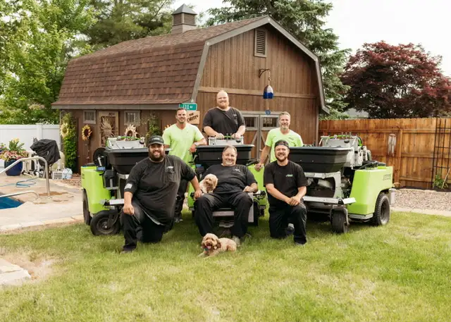 Field of Dreams Lawn Care team with their dog at the company office in Independence, Ohio